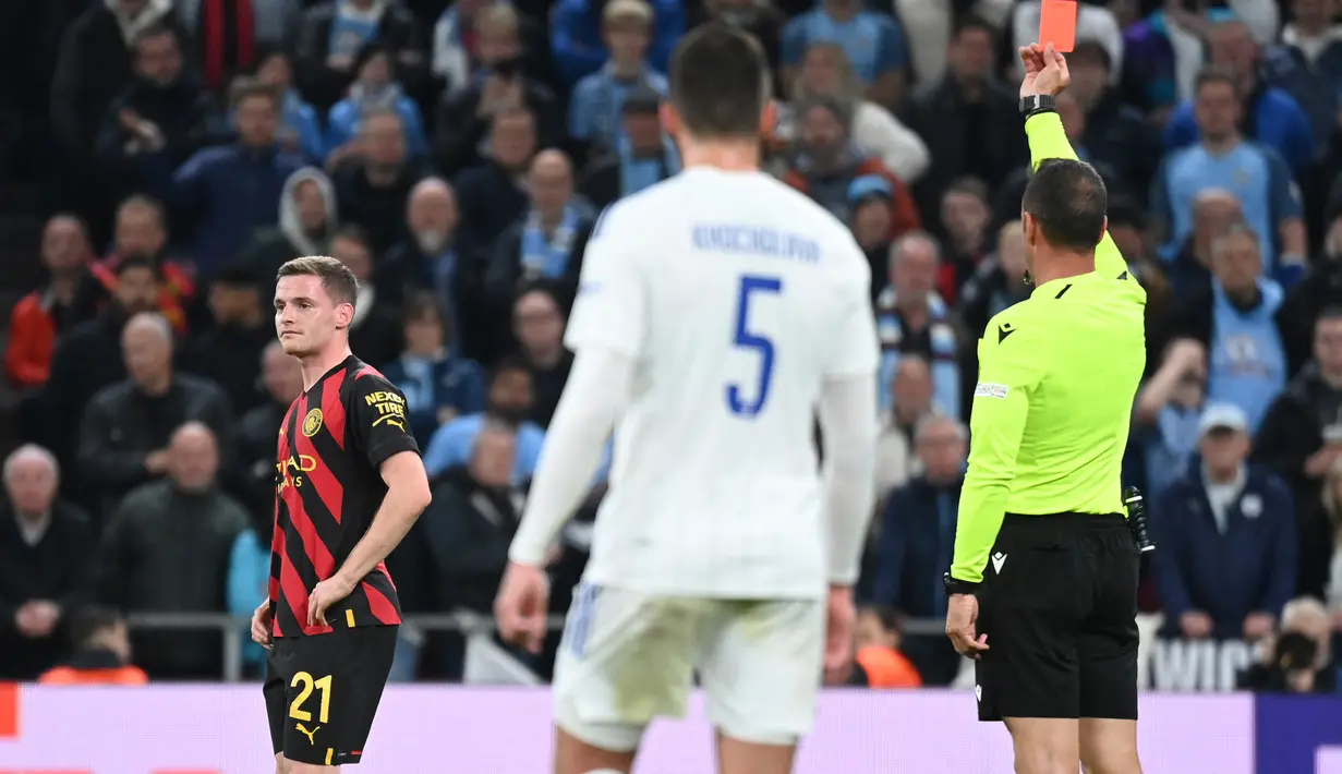 Manchester City harus bermain dengan 10 pemain tepat saat laga berjalan setengah jam. Sergio Gomez dikartu merah wasit usai tertangkap VAR melakukan pelanggaran dengan menarik Hakon Haraldsson yang berpeluang mencetak gol tepat di depan kotak penalti. (AFP/Jonathan Nackstrand)