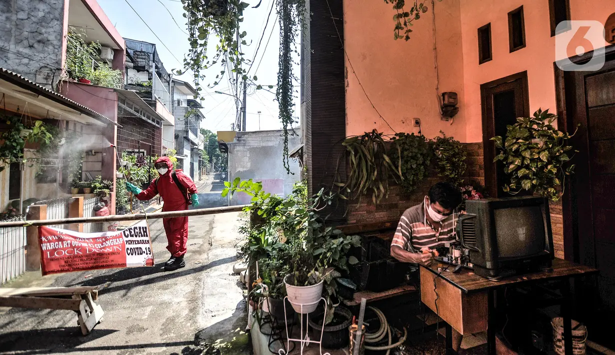 Petugas damkar Kecamatan Cipayung menyemprotkan disinfektan saat sterilisasi wilayah Zona Merah di RT 003/003, Cilangkap, Jakarta, Selasa (25/5/2021). Petugas terus melakukan pencegahan penyebaran Covid-19 di kawasan ini, salah satunya dengan menyemprotkan disinfektan. (merdeka.com/Iqbal S Nugroho)
