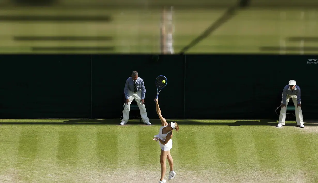 Petenis Rusia, Maria Sharapova, melancarkan servis ke arah Serena Williams dalam semifinal tunggal putri Turnamen Tenis Wimbledon di London, Inggris. (9/7/2015). (REUTERS/Suzanne Plunkett)