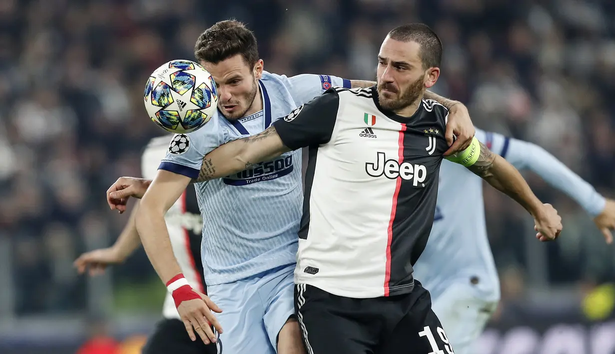 Bek Juventus, Leonardo Bonucci berebut bola dengan gelandang Atletico Madrid, Saul Niguez pada pertandingan Grup D Liga Champions di stadion Allianz di Turin, Italia (26/11/2019). Juventus menang tipis atas Atletico Madrid 1-0. (AP Photo/Antonio Calanni)