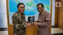 Direktur SCM Imam Sudjarwo (kiri) memberikan cenderamata kepada Menko Polhukam Mahfud Md di Kantor Kemenko Polhukam, Jakarta, Kamis (12/3/2020). Jajaran Grup Emtek mengunjungi Mahfud Md untuk bersilatuhrami. (Liputan6.com/Faizal Fanani)