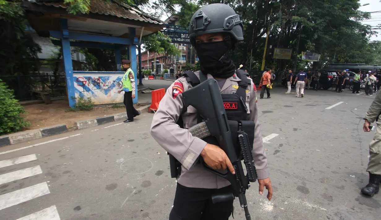 Petugas bersenjata berjaga di TKP terjadinya teror di Cikokol, Tangerang, Banten, Kamis (20/10). Dua anggota satlantas Polres Tangerang juga terkena tusukan dari pelaku yang diduga simpatisan ISIS. (Liputan6.com/Stringer)