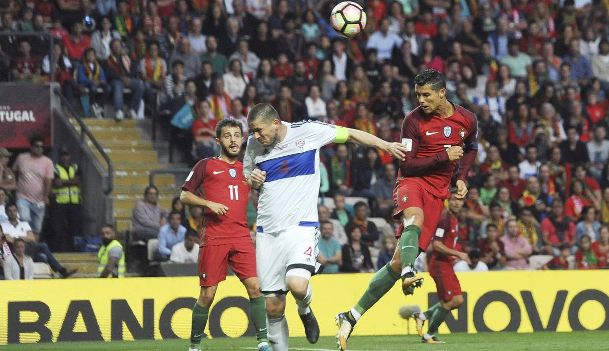 Sundulan Cristiano Ronaldo melewati jangkauan pemain Kepulauan Faroe, Atli Gregersen pada laga Grup B Kualifikasi Piala Dunia 2018 di Bessa Stadium, Porto, (31/8/2017). Portugal menang 5-1. (AP/Paulo Duarte)