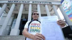 Pemohon pengajuan uji materi Pasal 222 UU No.7 Tahun 2017, Hadar Nafis Gumay menunjukkan berkas permohonan uji materi syarat ambang batas pencalonan presiden. di depan Gedung Mahkamah Konstitusi, Jakarta, Kamis (21/6). (Liputan6.com/Helmi Fithriansyah)