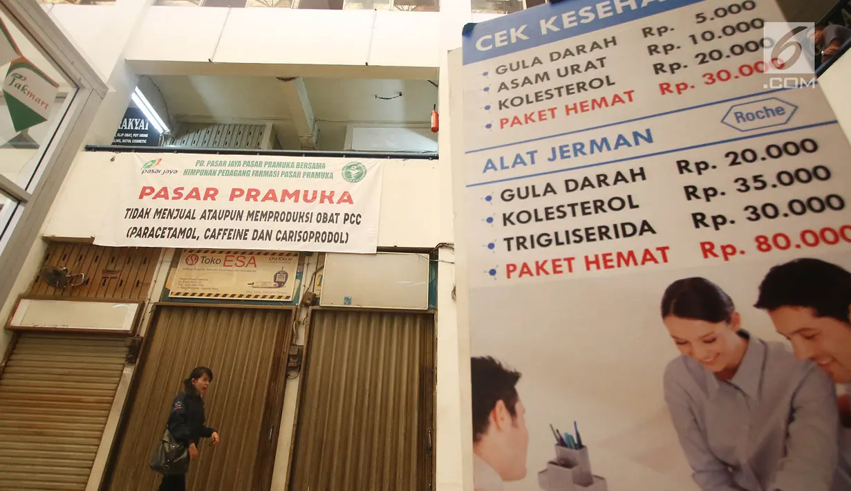 Seorang pengunjung melintas di depan kios Pasar Pramuka, Matraman, Jakarta yang tutup, Rabu (27/9). Para pedagang menutup toko mereka lantaran harus mengajukan izin peralihan dari apotek rakyat ke apotek reguler. (Liputan6.com/Immanuel Antonius)