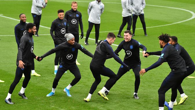 Para pemain Inggris tertawa saat bermain Kabaddi selama sesi pelatihan tim  di Staplewood Campus di southampton, Inggris selatan (9/9/2019). Inggris akan bertanding melawan Kosovo pada grup A Kualifikasi Euro 2020 di Stadion Saint Mary. (AFP Photo/Glyn Kirk)