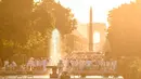 Peserta dalam balutan serba putih  berkumpul untuk Dinner en Blanc atau "makan malam putih" di Tuileries Gardens, Paris, Kamis (6/6/2019). Acara selesai ketika tengah malam dan peserta diminta untuk meninggalkan tempat acara dengan tertib dan tidak meninggalkan barang bawaannya (Lucas BARIOULET/AFP)