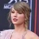 Penyanyi Taylor Swift berpose saat tiba menghadiri Billboard Music Awards di MGM Grand Garden Arena di Las Vegas (20/5).Taylor Swift tampil cantik dengan gaun Versace warna merah muda dengan belahan paha tinggi. (AP Photo/Jordan Strauss)