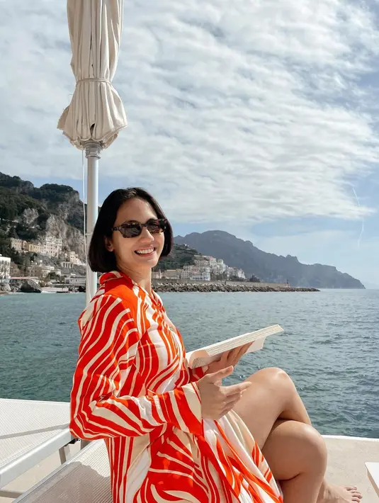 Cantiknya Pevita Pearce dibalut dress bernuansa oranye di atas kapal menikmati hangat sinar matahari. [Foto: Instagram/pevpearce]