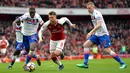 Gelandang Arsenal, Aaron Ramsey, melewati kepungan pemain Stoke pada laga Premier league di Stadion Emirates, London, Minggu (1/4/2018). Arsenal menang 3-0 atas Stoke. (AFP/Oliver Greenwood)