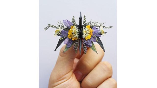 Seniman ini juga menggunakan bunga untuk hiasan origami burung.