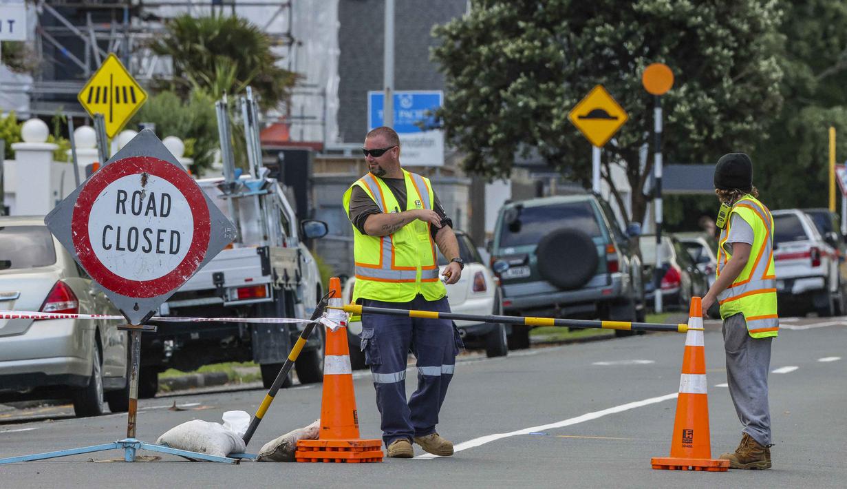 Sejumlah media lokal melaporkan beberapa helikopter dikerahkan untuk mendukung operasi pencarian dan penyelamatan yang masih berlangsung. Tampak dalam foto, petugas darurat menutup jalan setelah tanah longsor sementara pencarian sedang dilakukan oleh layanan darurat setempat untuk orang hilang di Gunung Maunganui, Tauranga, Selandia Baru pada Kamis 22 Januari 2026. (DJ MILLS/AFP)