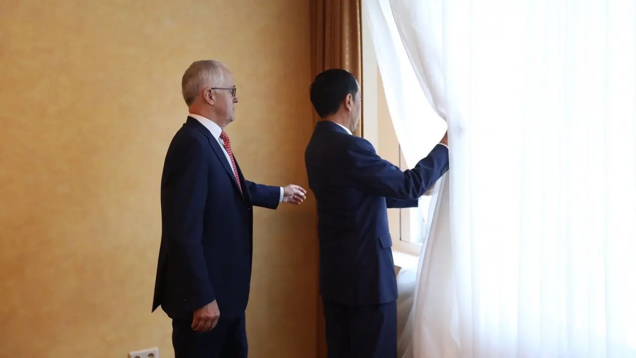 Presiden Jokowi dan PM Turnbull melihat jalannya unjuk rasa dari balik jendela ruangan pertemuan mereka.