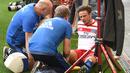 Gelandang Hamburg Nicolai Mueller menerima perawatan usai mencetak gol ke gawang Augsburg pada Divisi Satu Bundesliga di Hamburg, Jerman (20/8). Perayaan gol Mueller membuatnya cedera dan harus absen selama tujuh bulan. (AFP/PHBS/Daniel Bockwoldt)