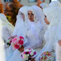 Mempelai perempuan menunggu prosesi pernikahan pada perayaan Rusia City Day di Grozny, Rusia, (5/10). Sebanyak 199 pasangan menikah di Taman Bunga Grozny pada perayaan tersebut. (AP Photo / Musa Sadulayev)