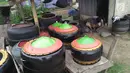 Agus Baiku mengolah ban bekas menjadi produk berkelas di Desa Pentadio Barat, Kabupaten Gorontalo, Senin (31/12). Ban mobil bekas ditempat ini diubah menjadi tempat sampah, loyang, ayunan anak-anak serta pot bunga. (Liputan6.com/Arfandi Ibrahim)