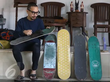 Pemilik brand kacamata kayu Kabau Bonny Andrew memilih sebuah papan skateboard di studio Namines, Jakarta (18/08). Kacamata kayu Kabau Brand lokal asal Jakarta dirintis tahun 2012 di buat dengan papan bekas skateboard.(Liputan6.com/Herman Zakharia)