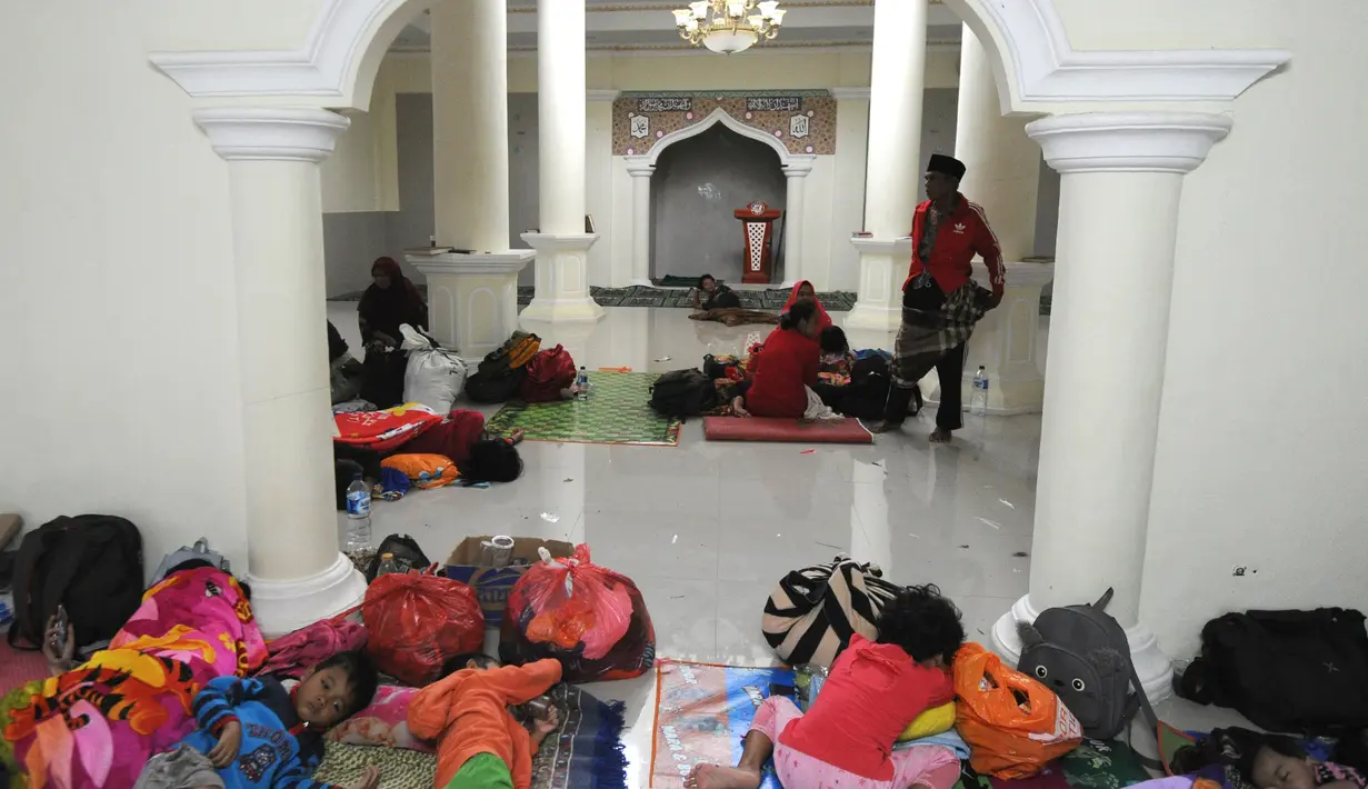 Pengungsi bencana tsunami beristirahat di sebuah masjid di Tenjolahang, provinsi Banten, Rabu (26/12). Saat ini tercatat ada 1.485 orang luka-luka, 154 orang hilang dan 16.082 orang  mengungsi selepas tsunami Selat Sunda. (Sonny TUMBELAKA / AFP)