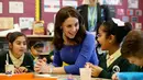 The Duchess of Cambridge, Kate Middleton berdialog dengan murid kelas tiga saat mengunjungi Roe Green Junior School di London, Selasa (23/1). (Jonathan Brady/Pool via AP)