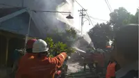 Petugas PMK saat memadamkan api di rumah kos yang terbakar di Kebalen Kulon Gang II Nomor 9, Selasa (29/5/2018) sore. (Suarasurabaya/Istimewa)