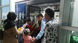 Petugas membantu penumpang menaiki bus Transjakarta koridor 13 rute Tendean-Ciledug, Jakarta, Minggu (13/8). selain rute Tendean-Ciledug, PT Transjakarta juga memberi layanan secara cuma-cuma untuk rute Ragunan-Ciledug. (Liputan6.com/Herman Zakharia)