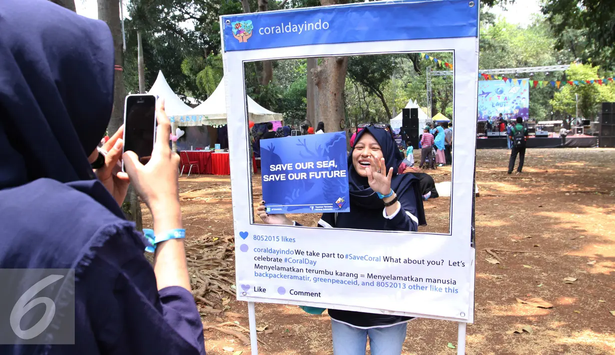 Pengunjug berfoto di dalam frame dalam festival laut 2015 di taman Kridaloka,  Senayan, Jakarta, Sabtu (19/9/2015). Festival bertujuan untuk mengenalkan dunia laut Indonesia kepada masyarakat serta untuk menjaganya. (Liputan6.com/Angga Yuniar)