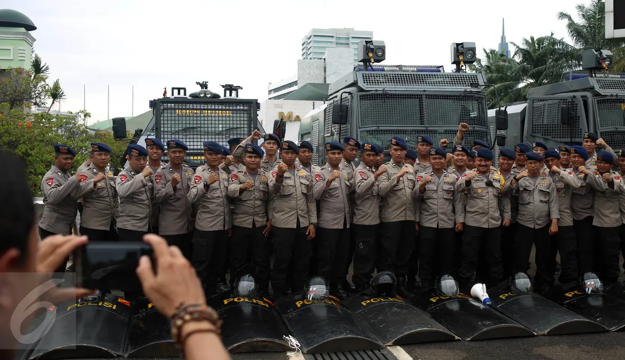 Petugas kepolisian berpose saat berjaga pada Aksi 212 - Jilid 2 di Kompleks Parlemen, Senayan, Jakarta, Senin (20/2). Kurang lebih 10 ribu Pasukan Prajurit Gabungan TNI-Polri di terjunkan saat Aksi tersebut. (Liputan6.com/Johan Tallo)