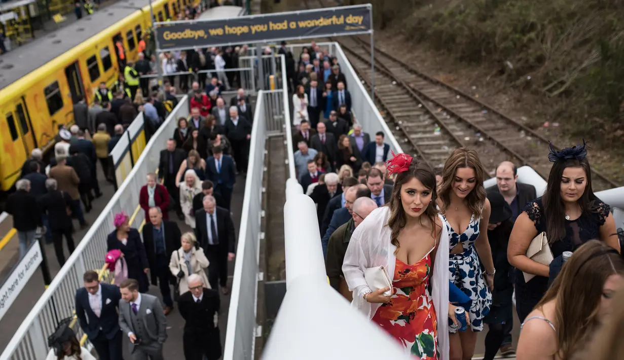 Sejumlah racegoers berdandanan seksi dan modis saat menghadiri Festival Grand National di arena Aintree, Liverpool, Inggris, Jumat (7/4). Kehadiran racegoers memberikan nuansa tersendiri di kompetisi pacuan kuda terbesar tersebut. (AFP Photo / Oli Scarff)