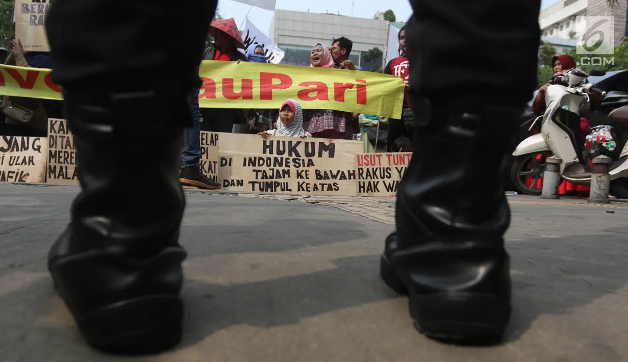 Polisi berjaga saat warga Pulau Pari menggelar aksi di depan PN Jakarta Utara, Kamis (12/7). Mereka menolak dugaan kriminalisasi terhadap Ketua RW Pulau Pari Sulaiman dalam kasus penyerobotan lahan. (Liputan6.com/Arya Manggala)