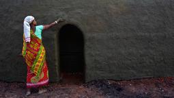 Buruh wanita mengoleskan campuran tanah liat dan kotoran sapi di atas tungku saat ia bekerja di sebuah tungku batu bata di Gauhati, India (22/11). Sebagian besar buruh di sini mendapatkan Rupee 120 (kurang dari 2 Dolar) per hari. (AP Photo/Anupam Nath)