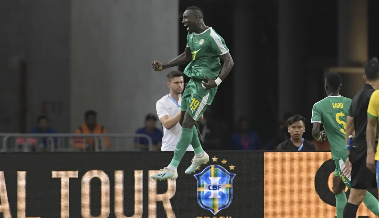 Penyerang Senegal, Famara Diedhiou berselebrasi usai mencetak gol ke gawang Brasil pada pertandingan persahabatan di Stadion Nasional di Singapura (10/10/2019). Brasil bermain imbang dengan Senegal 1-1. (AFP Photo/Roslan Rahman)