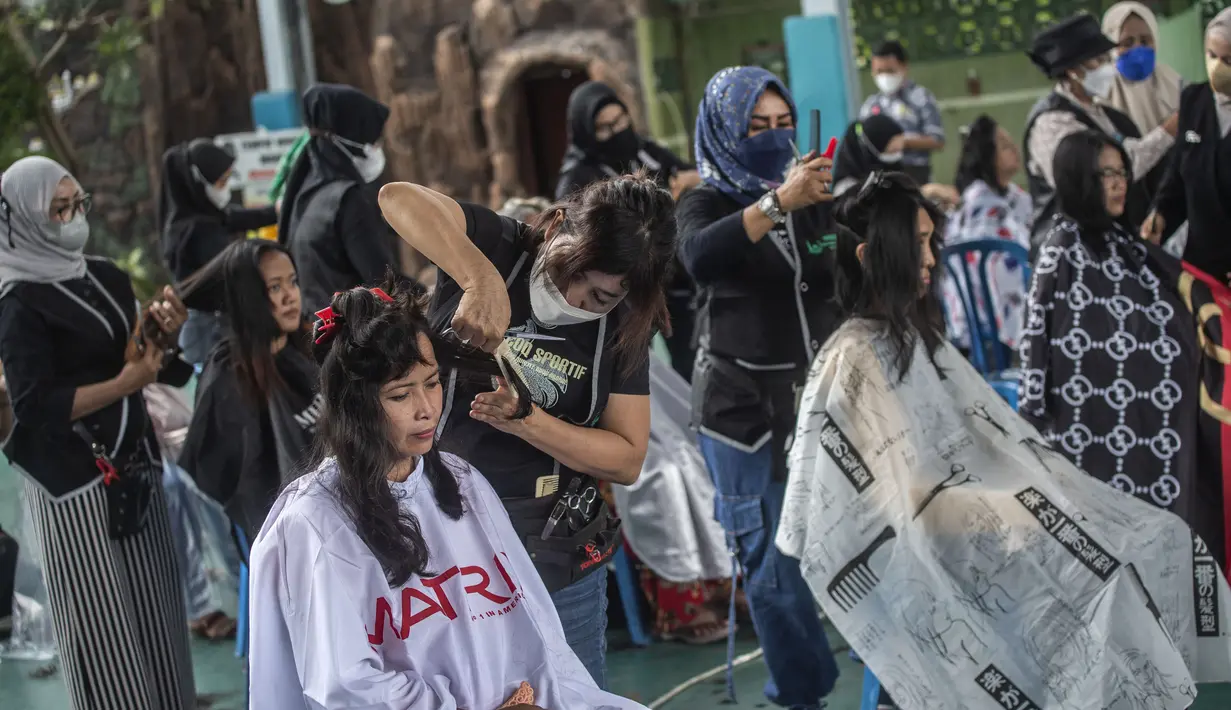Penata rambut memberikan potongan rambut gratis sebagai bagian dari amal Muslim untuk yang membutuhkan saat umat Islam di seluruh dunia merayakan bulan suci Ramadhan di Muhammad Cheng Hoo di Surabaya (18/4/2022). (AFP/Juni Kriswanto)