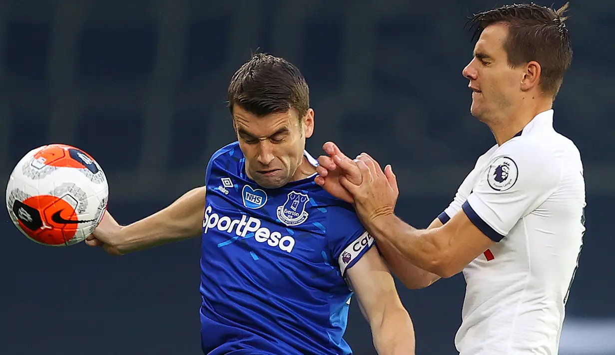 Gelandang Tottenham Hotspur, Giovani Lo Celso (berebut bola dengan bek Everton, Seamus Coleman pada lanjutan pertandingan Liga Inggris di Tottenham Stadium, Selasa (7/7/2020) dini hari. Tottenham Hotspur susah payah mengalahkan Everton 1-0. (Richard Heathcote/POOL/AFP)