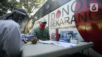 Petugas Palang Merah Indonesia (PMI) memeriksa kondisi pendonor dekat mobil donor darah keliling, Tangerang Selatan, Banten, Jumat (17/7/2020). PMI mengintensifkan pengoperasian mobil donor darah keliling untuk memenuhi persediaan stok darah saat pandemi COVID-19. (merdeka.com/Dwi Narwoko)