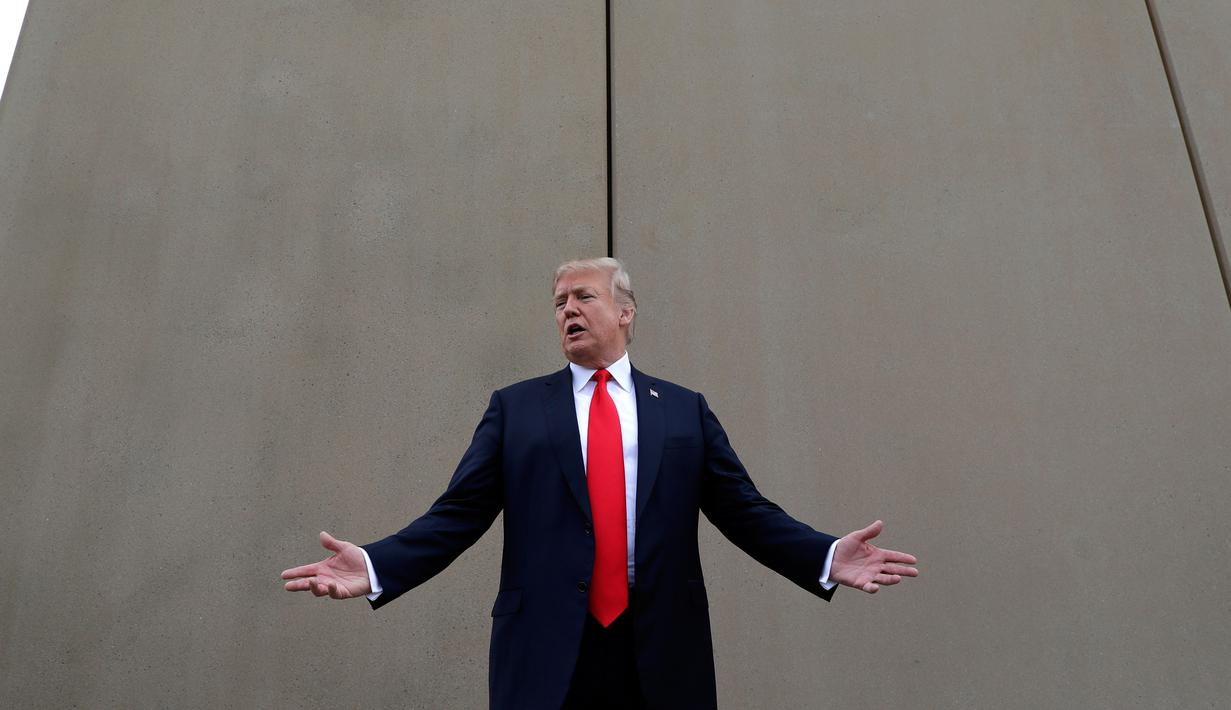 Presiden AS, Donald Trump berbincang saat melakukan perjalanan untuk melihat prototipe tembok perbatasan AS dan Meksiko di San Diego, Selasa (13/3). Tembok ini adalah perwujudan dari janji Trump pada kampanye presiden 2016 lalu. (AP/Evan Vucci)