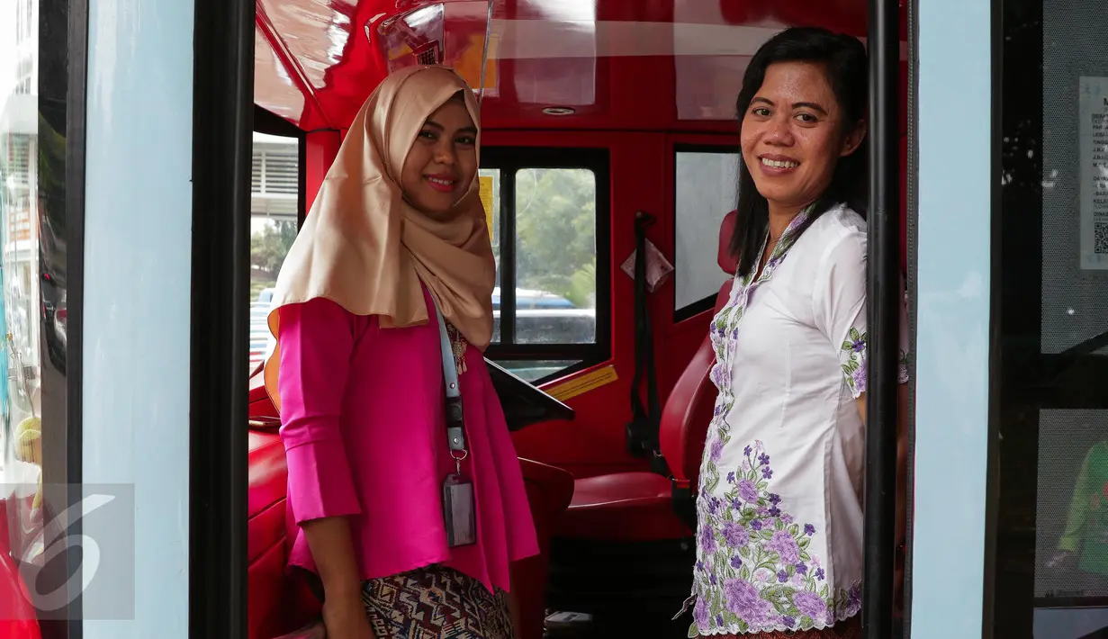 Petugas bus tingkat wisata TransJakarta mengenakan kebaya saat menjalankan tugasnya di Jakarta, Jumat (21/4). Dalam rangka Hari Kartini, semua pramudi perempuan bus pariwisata dan Transjakarta mengenakan kebaya. (Liputan6.com/Faizal Fanani)