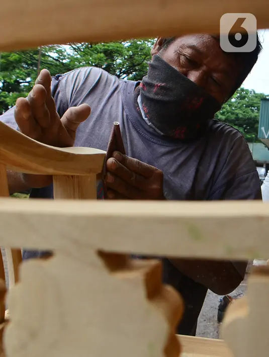 Pekerja menghaluskan furnitur atau perlengkapan rumah berbahan kayu dari Jepara di Ciputat, Tangerang Selatan, Selasa (14/9/2021). Pedagang di tempat tersebut mengakui selama PPKM ini daya beli masyarakat terhadap furnitur meningkat. (Liputan6.com/Johan Tallo)