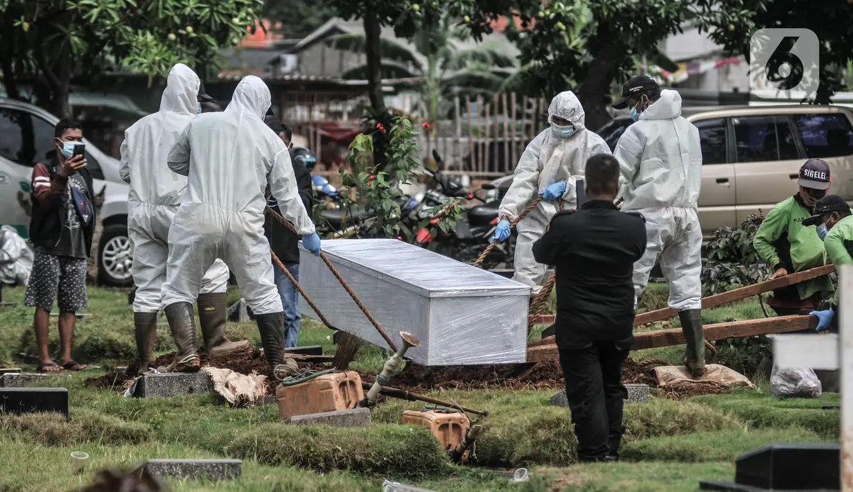 Proses pemakaman pasien Covid-19 isolasi mandiri di TPU Pondok Kelapa, Jakarta, Selasa (13/7/2021). Para pasien isolasi mandiri ini meninggal karena berbagai alasan, mulai dari terlambat mendapatkan pertolongan, rumah sakit penuh hingga tidak terpantau dengan baik. (merdeka.com/Iqbal S Nugroho)