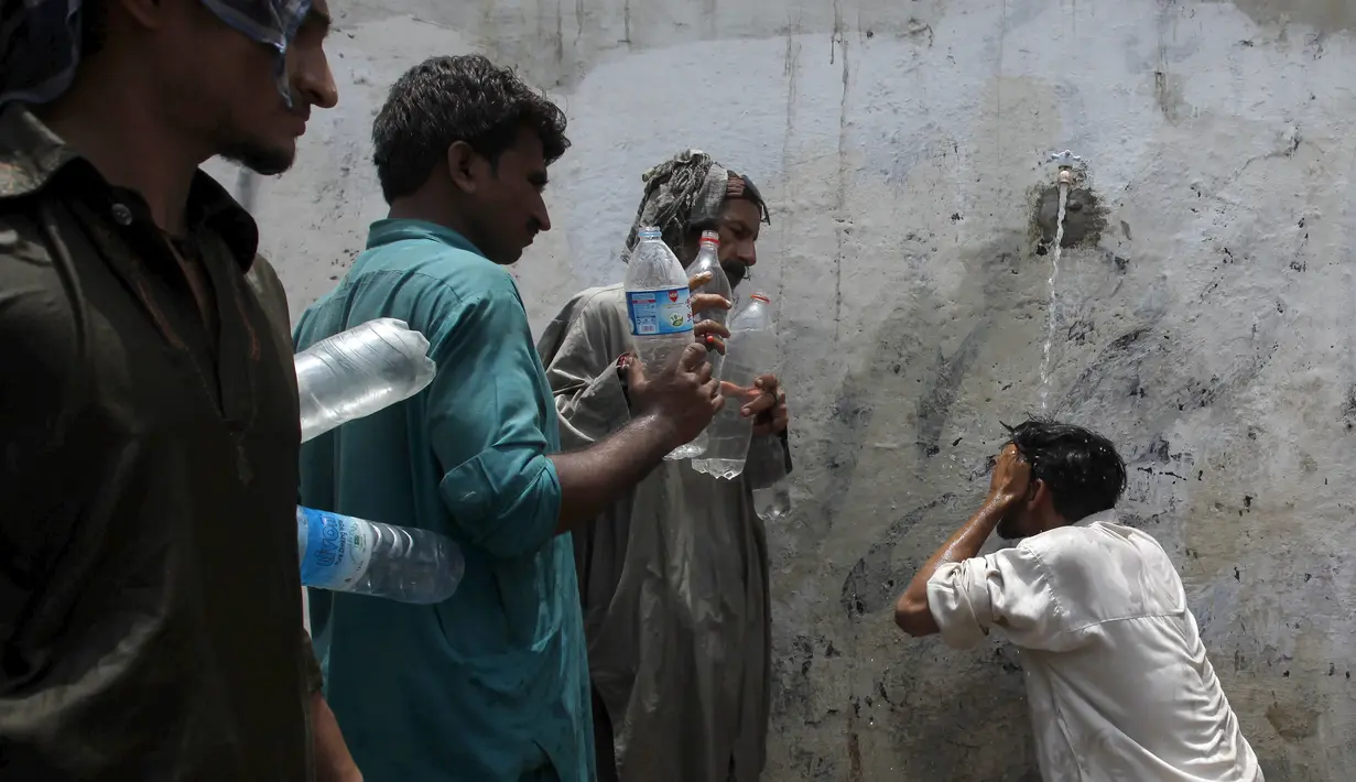 Sejumlah orang saat menunggu giliran untuk mengambil air saat cuaca panas yang ekstrem di Karachi, Pakistan, (23/6/2015). Gelombang panas yang telah menewaskan lebih dari 400 jiwa di kota selatan Pakistan. (REUTERS/Akhtar Soomro)