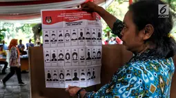 Warga menunjukkan contoh surat suara saat simulasi pemungutan dan pencoblosan surat suara Pemilu 2019 di Taman Suropati, Jakarta, Rabu (10/4). Simulasi pemungutan surat suara dilakukan untuk meminimalisir kesalahan dan kekurangan saat pencoblosan pemilu pada 17 April nanti (Liputan6.com/Johan Tallo)