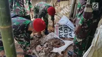 Prajurit Kopassus membersihkan puing-puing bangunan yang ambruk di Desa Citalahap, Kabupaten Lebak, Bogor (23/1). Wilayah tersebut merupakan satu lokasi terparah terkena dampak gempa. (LIputan6.com/Pool/Kopassus)