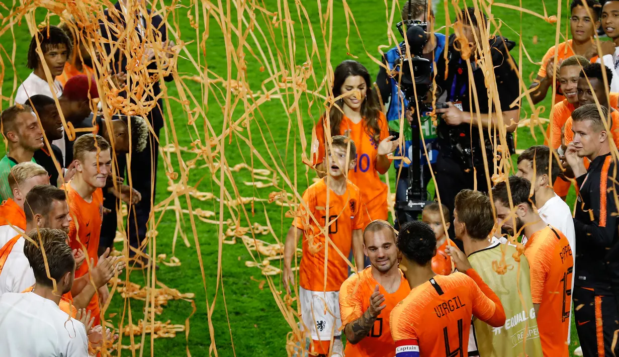 Gelandang Timnas Belanda, Wesley Sneijder bersama istri dan anaknya menyapa rekan setimnya usai laga persahabatan melawan Peru di Amsterdam, Kamis (6/9). Sneijder mengungkapkan kalau ia akan merindukan menggunakan jersey Belanda. (AP Photo/Peter Dejong)