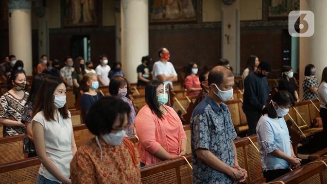 Umat Katolik melaksanakan ibadah misa dengan tetap mengenakan masker di Gereja Katedral Jakarta, Minggu (12/7/2020). Gereja Katedral Jakarta kembali menggelar misa bagi umat Katolik dengan menerapkan protokol kesehatan untuk mencegah penularan Covid-19. (Liputan6.com/Immanuel Antonius)