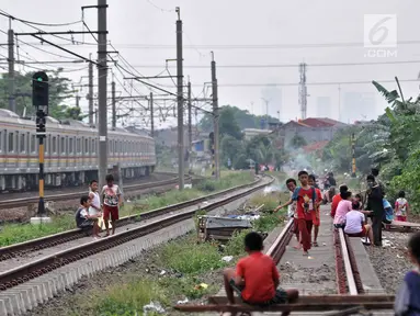 Anak-anak bermain layang-layang di rel kereta api kawasan Jakarta Timur, Kamis (3/1). Minimnya lahan terbuka hijau memaksa anak-anak setempat memilih kawasan rel kereta api sebagai lokasi bermain. (Merdeka.com/Iqbal Nugroho)