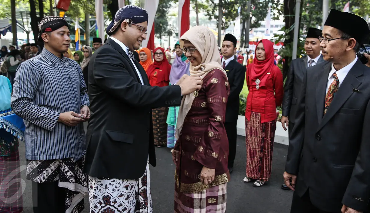 Mendikbud Anies Baswedan memberikan setia lencana kepada pegawai usai upacara Hari Pendidikan Nasional 2016 di Kemendikbud, Jakarta, Senin (2/5).  Upacara diikuti pegawai Kemendikbud dan perwakilan sekolah-sekolah di Jakarta. (Liputan6.com/Faizal Fanani)