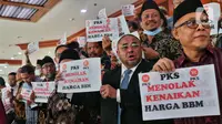Anggota Fraksi PKS memegang poster bertuliskan “Tolak Kenaikan Harga BBM” saat Rapat Paripurna ke-4 masa persidangan I tahun 2022-2023 di Kompleks Parlemen, Senayan, Jakarta, Selasa (6/9/2022). Fraksi Partai Keadilan Sejahtera (PKS) mengambil sikap walkout dari Rapat Paripurna DPR atas penolakan kenaikan harga bahan bakar minyak (BBM). (Liputan6.com/Angga Yuniar)