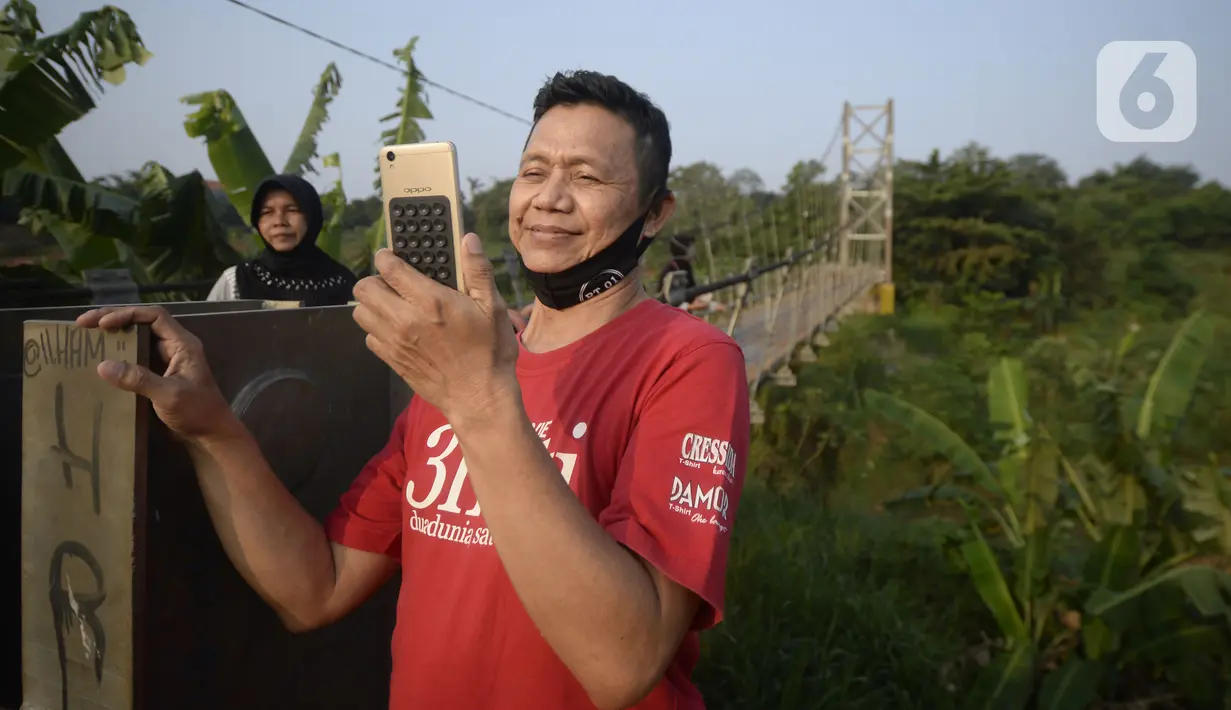 Warga asyik berswafoto di atas jembatan gantung, Kelurahan Curug, Bojongsari, Kota Depok, Jawa Barat, Senin (24/8/2020). Setiap sore, warga sekitar bermain di jembatan tersebut sambil menikmati matahari tenggelam. (merdeka.com/Dwi Narwoko)