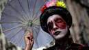 Peserta berpose dengan kostum dan dandanan menyerupai zombie selama acara Zombie Walk di Sao Paulo, Brasil, Sabtu (2/11/2019). Ratusan orang turun ke jalan memakai kostum karakter horor pada acara tahunan yang digelar sejak 2006 pada Hari Para Arwah. (Miguel SCHINCARIOL / AFP)