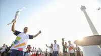 Gubernur DKI Jakarta Anies Baswedan mengangkat obor saat puncak Kirab Obor Asian Games 2018 di Jakarta, Sabtu (18/8). Obor diarak mulai dari Monumen Nasional (Monas) menuju Stadion Utama Gelora Bung Karno (GBK). (Liputan6.com/Faizal Fanani)