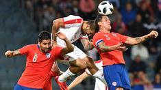 Aksi pemain Serbia, Aleksandar Mitrovic (tengah) saat duel dengan dua apemain Chili pada laga uji coba di Merkur Arena, Graz, Austria, (4/6/2018).  Serbia kalah dari Chili 0-1. (AFP/Joe Klamar)